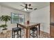 Cozy dining area featuring a table with marble top, wicker stools, a ceiling fan and a window at 11187 Blythville Rd, Spring Hill, FL 34608