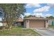 Charming single-story home with a brick facade, large front yard, and two-car garage, creating a welcoming curb appeal at 11187 Blythville Rd, Spring Hill, FL 34608