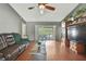 Comfortable living room featuring hardwood floors, a ceiling fan, and sliding glass doors leading to the outdoors at 11187 Blythville Rd, Spring Hill, FL 34608