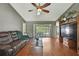 Comfortable living room featuring hardwood floors, a ceiling fan, and sliding glass doors leading to the outdoors at 11187 Blythville Rd, Spring Hill, FL 34608