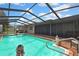 Screened in pool with clear water, decking, and exterior access door at 11187 Blythville Rd, Spring Hill, FL 34608