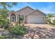 Charming single-story home featuring a well-manicured lawn and an attached two-car garage at 1135 Millbrook Cir, Bradenton, FL 34212