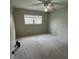 This bedroom has carpeting, a ceiling fan, and a large window letting in ample light at 11485 Oakhurst Rd # 1200-214, Largo, FL 33774