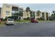 Condo building featuring well-kept landscaping and an expansive parking lot at 11485 Oakhurst Rd # 1200-214, Largo, FL 33774