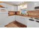 Traditional kitchen with white cabinets, stainless steel sink, and tile backsplash at 11485 Oakhurst Rd # 1200-214, Largo, FL 33774
