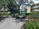 A beautiful outdoor patio area with tables, chairs, umbrellas and lush, mature landscaping at 11485 Oakhurst Rd # 1200-214, Largo, FL 33774