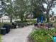 A beautiful outdoor patio area with tables, chairs, umbrellas, grills and lush, mature landscaping at 11485 Oakhurst Rd # 1200-214, Largo, FL 33774