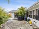 Outdoor patio with seating, grill, and sliding glass doors to the main house, surrounded by palm trees at 11762 Barb Ct, Seminole, FL 33778