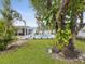 Spacious backyard featuring a sparkling pool, patio area, tropical landscaping, and mature trees at 11762 Barb Ct, Seminole, FL 33778