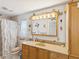 Bathroom featuring a single sink vanity, decorative mirror, and shower with curtain at 11762 Barb Ct, Seminole, FL 33778