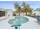 Beautiful kidney shaped pool surrounded by a concrete patio, lush tropical landscaping, and privacy fencing at 11762 Barb Ct, Seminole, FL 33778