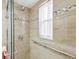 Modern accessible shower with tiled walls and a glass door at 11762 Barb Ct, Seminole, FL 33778