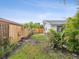 Grassy side yard with wooden fence, privacy landscaping, and garden beds at 11762 Barb Ct, Seminole, FL 33778