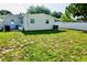 Spacious backyard with lush green grass, a privacy fence, and ample room for activities at 135 Emerald Ln, Largo, FL 33771