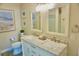 Bright bathroom featuring double sinks, marble countertops, framed mirrors, and tasteful coastal decor at 135 Emerald Ln, Largo, FL 33771