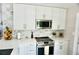 Modern kitchen design featuring stainless steel appliances, white cabinets, and quartz countertops at 135 Emerald Ln, Largo, FL 33771