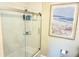 Modern bathroom featuring a glass-enclosed shower with built-in shelving and decorative wall art at 135 Emerald Ln, Largo, FL 33771