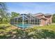Backyard view of the screened in-ground pool on this spacious lot at 15420 Aubrey Ave, Spring Hill, FL 34610