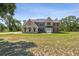 Charming two-story home with brick and stucco, complemented by green awnings and a lush lawn at 15420 Aubrey Ave, Spring Hill, FL 34610