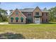 Spacious two-story home with brick and stucco, green awnings, and a well-maintained lawn at 15420 Aubrey Ave, Spring Hill, FL 34610