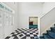 Welcoming foyer with black and white checkered flooring leading to the staircase and front door at 15420 Aubrey Ave, Spring Hill, FL 34610