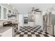 This kitchen boasts stainless steel appliances, white cabinets and black and white checkered flooring at 15420 Aubrey Ave, Spring Hill, FL 34610