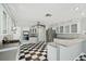 Bright kitchen with white cabinets, stainless steel appliances, and checkered floors at 15420 Aubrey Ave, Spring Hill, FL 34610