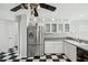 Bright kitchen featuring stainless steel refrigerator, checkered flooring, and white cabinetry at 15420 Aubrey Ave, Spring Hill, FL 34610
