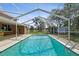 Enjoy this refreshing in-ground pool with a screened enclosure surrounded by greenery at 15420 Aubrey Ave, Spring Hill, FL 34610