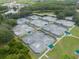 Aerial view of tennis courts in the community, with shaded picnic areas surrounded by lush landscaping at 17734 Long Ridge Rd, Tampa, FL 33647