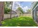 Spacious fenced backyard with lush grass, mature trees, and outdoor seating, perfect for relaxation and entertaining at 17734 Long Ridge Rd, Tampa, FL 33647