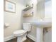 Powder room features a pedestal sink, two-shelf unit and tiled floors at 17734 Long Ridge Rd, Tampa, FL 33647