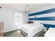 Bedroom featuring striped accent wall, white comforter, ceiling fan and natural light at 17734 Long Ridge Rd, Tampa, FL 33647