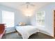 Comfortable carpeted bedroom with a white comforter and two windows providing natural light at 17734 Long Ridge Rd, Tampa, FL 33647
