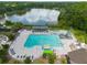 Aerial view of a large community pool with lap lanes, water slide, covered seating and a lake in the background at 17734 Long Ridge Rd, Tampa, FL 33647
