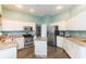 Open kitchen with white cabinets, granite counters, stainless appliances, and kitchen island at 17734 Long Ridge Rd, Tampa, FL 33647