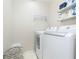 Practical laundry room equipped with a modern washer and dryer, shelving, and ample space for laundry tasks at 17734 Long Ridge Rd, Tampa, FL 33647