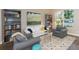 Bright living room featuring a large window, bookshelves, a painting and hardwood floors at 17734 Long Ridge Rd, Tampa, FL 33647