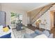 Cozy living room featuring hardwood floors, large window, and staircase at 17734 Long Ridge Rd, Tampa, FL 33647