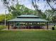Community picnic area offers covered seating with tables and views of a playground with mature shade trees at 17734 Long Ridge Rd, Tampa, FL 33647