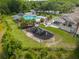 Aerial view of a community playground next to a pool, tennis courts, with green space and mature trees at 17734 Long Ridge Rd, Tampa, FL 33647
