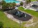 Aerial view of a community playground, lush lawn, and shade structure with tables near the pool at 17734 Long Ridge Rd, Tampa, FL 33647