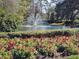 A scenic view of a lush pond with a fountain and colorful flowerbeds at 17734 Long Ridge Rd, Tampa, FL 33647