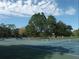 Well-maintained tennis courts provide great recreation, set against a backdrop of lush greenery and clear skies at 17734 Long Ridge Rd, Tampa, FL 33647