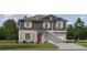 Charming two-story home with a gray exterior, symmetrical window placement, and a well-maintained lawn at 1805 Tropical Oasis Ave, Plant City, FL 33565