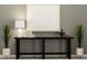 Modern hallway with decorative plants, a dark wood console table, and a lamp with a white shade at 1805 Tropical Oasis Ave, Plant City, FL 33565