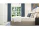 Bright bedroom featuring a large window, comfortable bed, and chic decor at 1813 Tropical Oasis Ave, Plant City, FL 33565