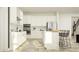 Beautiful, bright kitchen with white cabinets, stainless steel appliances, and an island with bar stools at 18469 Serene Lake Loop, Lutz, FL 33548