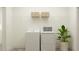 Bright laundry room with new washer and dryer and built in storage shelving at 18469 Serene Lake Loop, Lutz, FL 33548