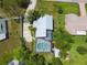 Aerial shot of home with pool, screened in area, lush yard, and metal roof at 18914 Geraci Rd, Lutz, FL 33548